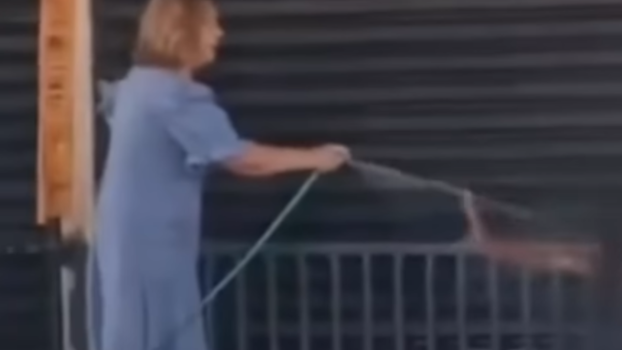 Mulher usa jato de água para tirar homem de calçada e vídeo viraliza