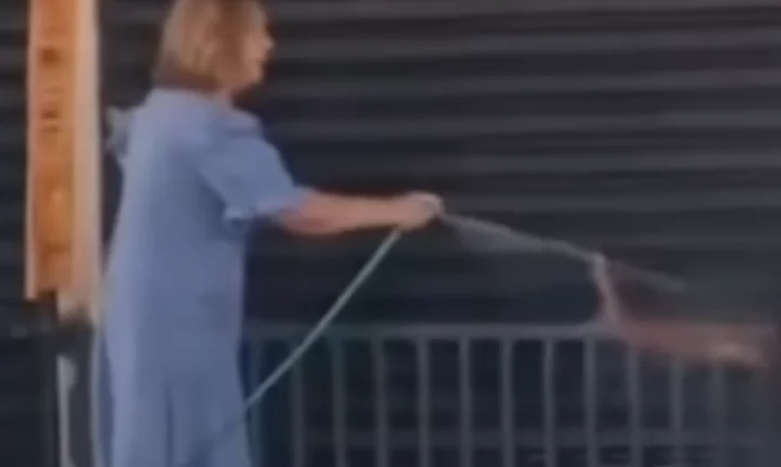 Mulher usa jato de água para tirar homem de calçada e vídeo viraliza